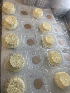 prepared cheese in the process of being stored in plastic containers