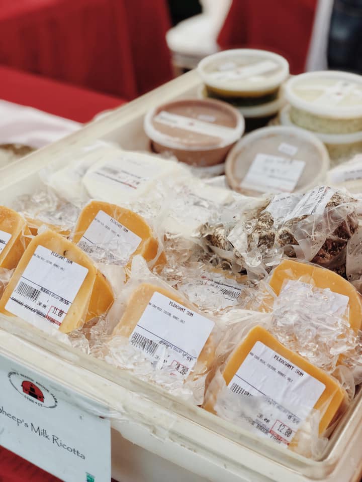 Multiple different types of cheese for sale in containers