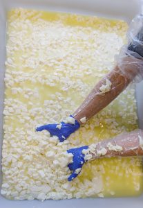 Worker handling cheese from a container