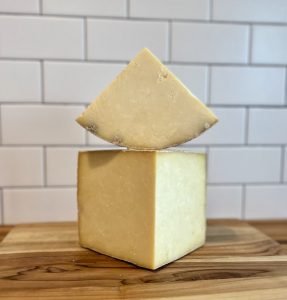 two pieces of cut cheese stacked atop a table